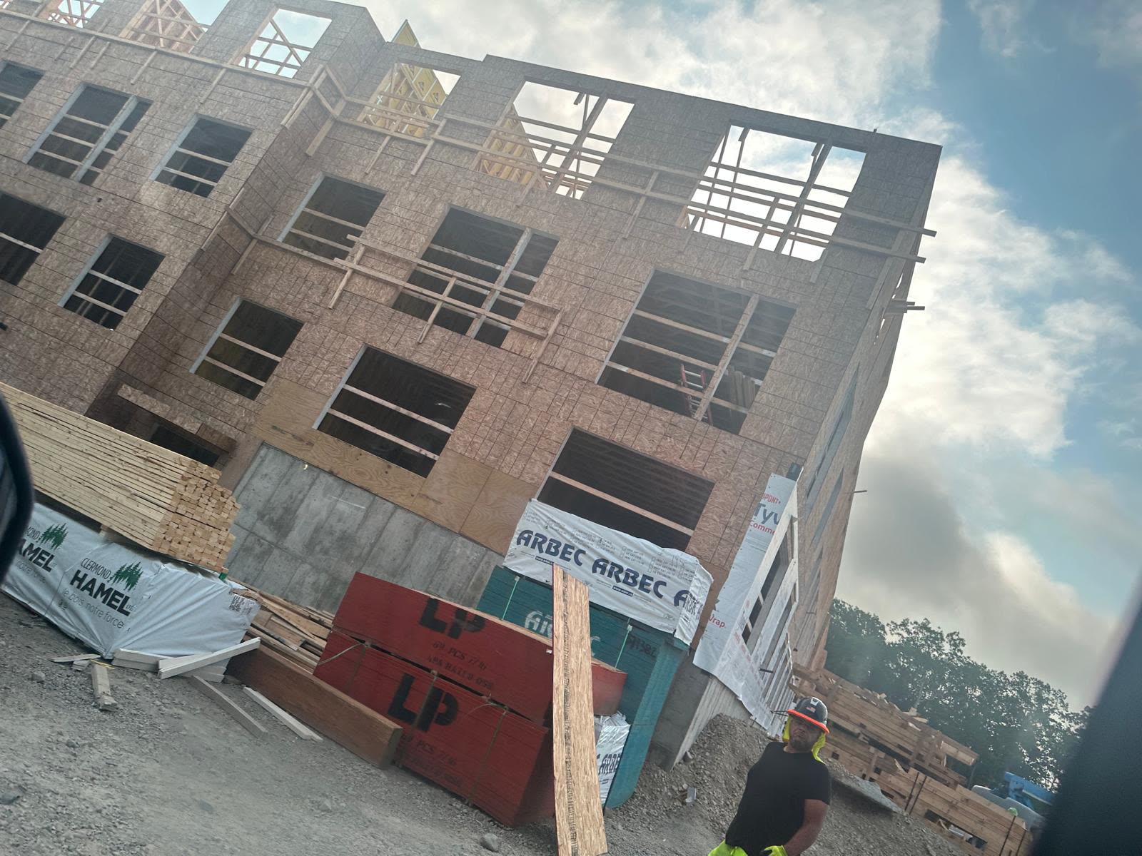 OSB bundles and lumber packages staged at a framing site