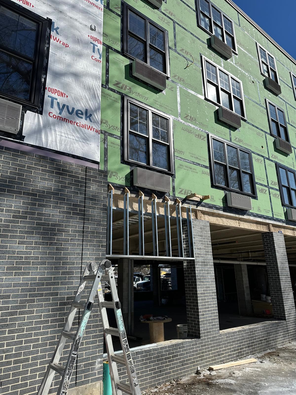 Winter facade with sun flare over sheathing and brick