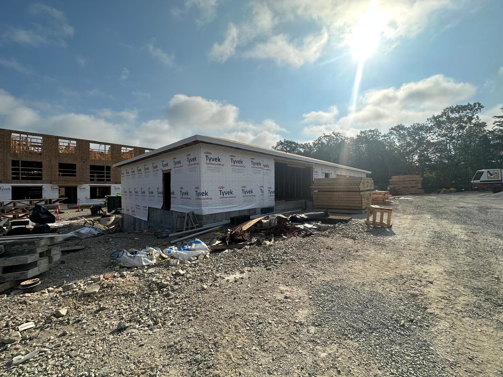Floor truss package staged in front of a Tyvek-wrapped building